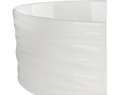 Detaljvy av en vit keramisk skål med en vågig yta