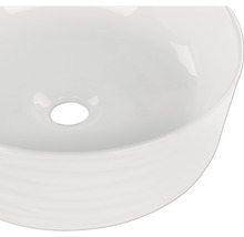 Ovanifrån av ett runt keramiskt handfat med avlopp