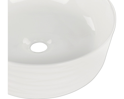 Ovanifrån av ett runt keramiskt handfat med avlopp