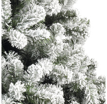 Närbild av en konstgjord julgran med snötäckta grenar.