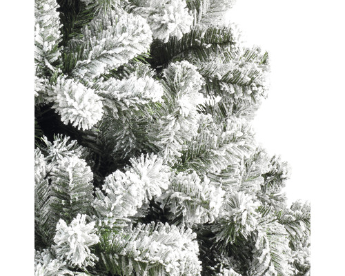 Närbild av en konstgjord julgran med snötäckta grenar.