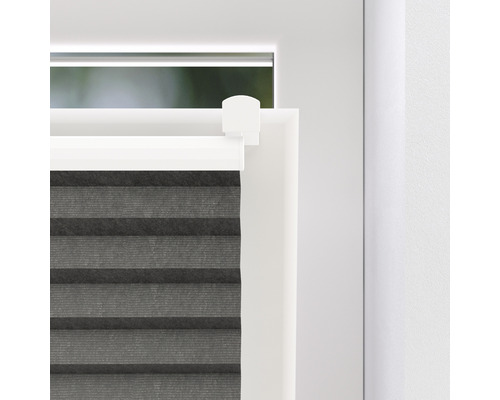 Detaljvy av en grå plisségardin på fönstret