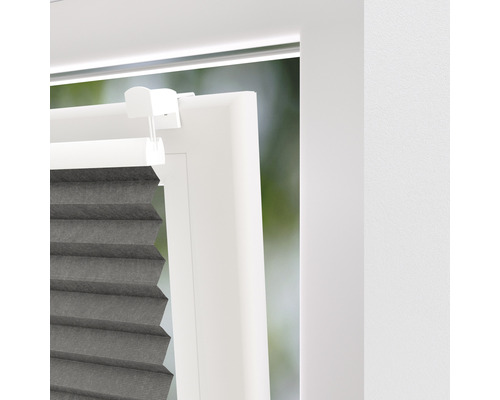 Detaljvy av en fönsterdekoration med plisségardiner och fönsterkarm