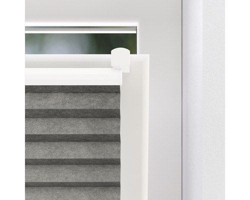 Detaljvy av en grå plisségardin på ett fönster