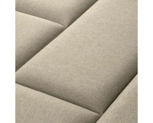 Närbild av en beige soffa med quiltad yta
