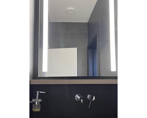 Modernt badrum med belyst spegel och armaturer