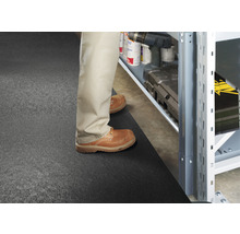 Scen med en person som står framför en hylla på en golvmatta