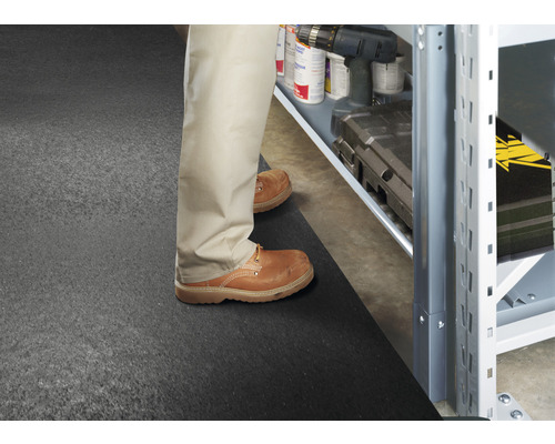 Scen med en person som står framför en hylla på en golvmatta