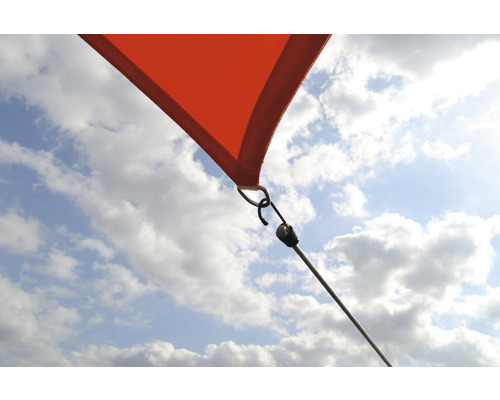 Närbild av ett solsegel med fästelement mot en blå himmel