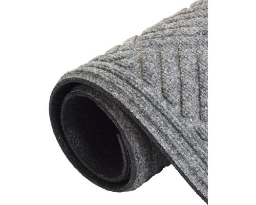 Grå dörrmatta med räfflat mönster, rullad.