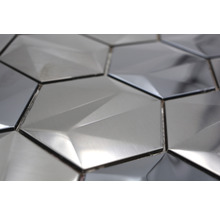 Närbild av hexagonformade, metallglänsande väggplattor med geometriskt mönster