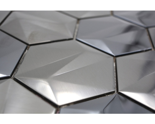 Närbild av hexagonformade, metallglänsande väggplattor med geometriskt mönster