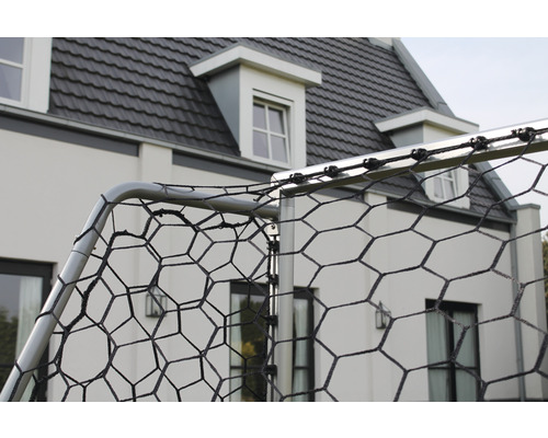 Detaljvy av ett fotbollsmål med nät framför ett hus