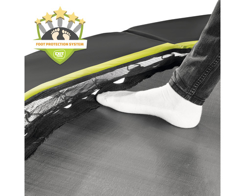 Närbild av en studsmatta med fotskyddssystem och en persons fot