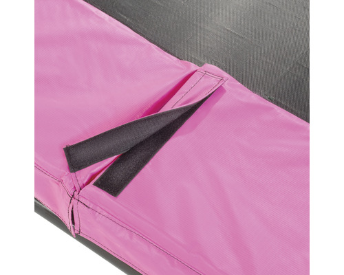 Närbild av en studsmatta med rosa kantskydd och kardborreband