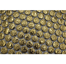 Närbild av en mosaik med små, runda, texturerade guldplattor