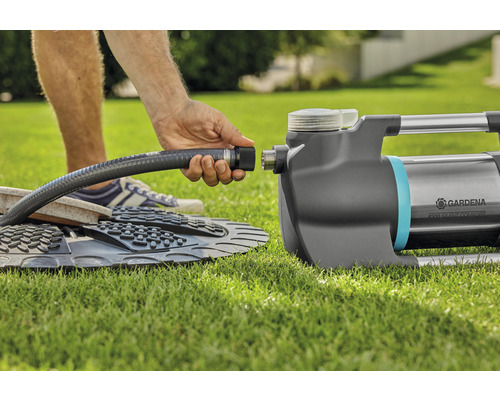 Anslutning av en trädgårdsslang till en trädgårdspump på gräsmatta