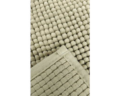 Detaljvy av en badrumsmatta med noppstruktur och kantade kanter