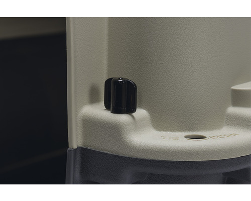 Detaljvy av en transportbehållare med en svart vridknapp och ett fästhål