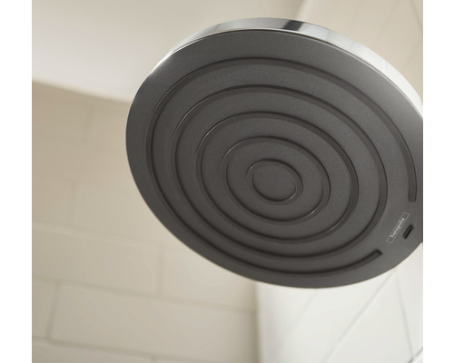 Detaljbild av ett duschhuvud med koncentriska cirklar på duschytan
