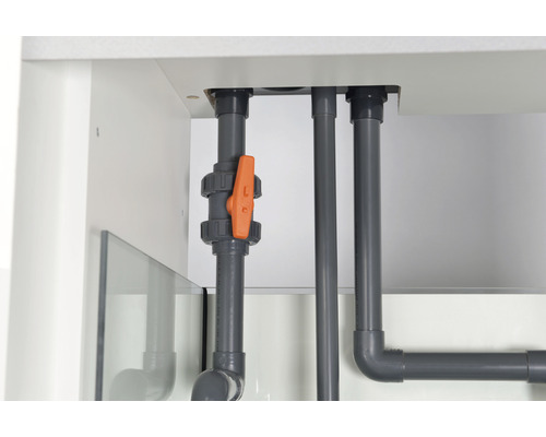 Detaljvy av grå rör med orange ventil under ett akvarium