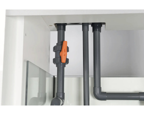 Grå plaströr med avstängningsventil i ett vitt akvariumskåp.