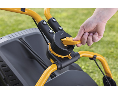 Närbild av en gräsklippares kontroller med en hand på den gula spaken