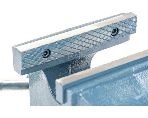 Detaljbild av ett skruvstycke med räfflade spännbackar