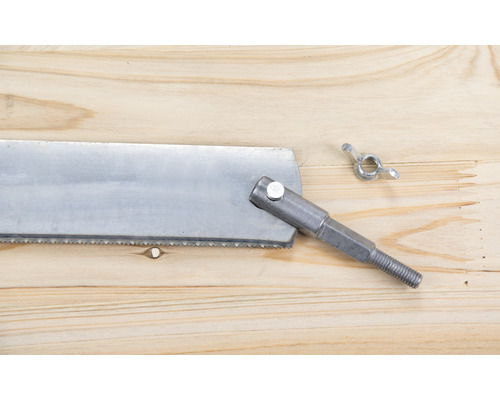 Handsåg med metallhandtag och vingmutter på ett träbord
