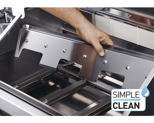 En man sätter in en rostfri stålplatta i en gasgrill.