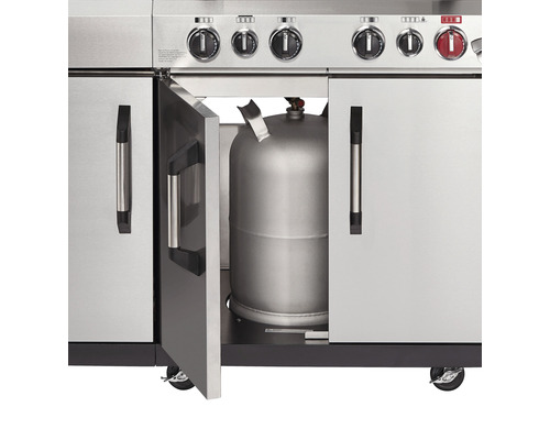 Detaljvy av en gasolgrill med en öppen dörr som visar en gasolflaska