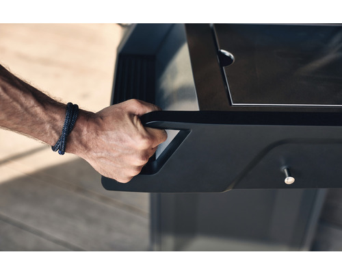 Närbild av en hand som skjuter en grillvagn