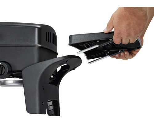 En person fäster ett fäste på en grill