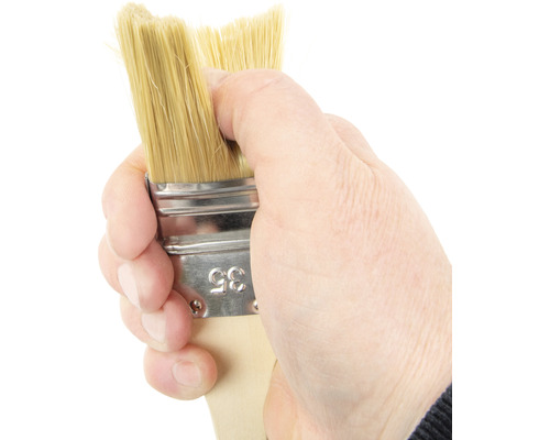 Hand håller pensel med naturborst, bredd 35 mm