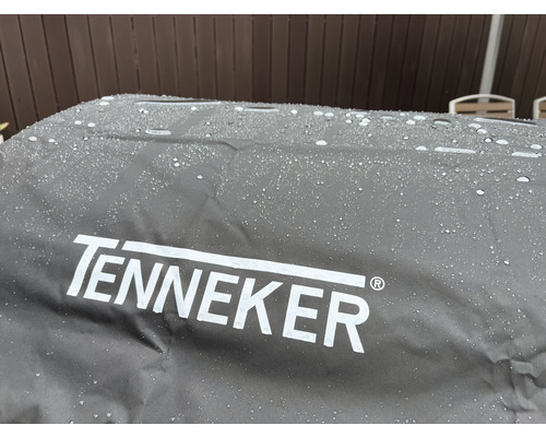Tenneker logotyp på ett grillskydd med vattendroppar