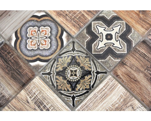 Närbild av mosaikplattor med blommönster och trästruktur.