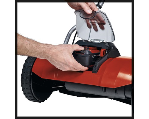 Sätta i batteriet i en gräsklippare.