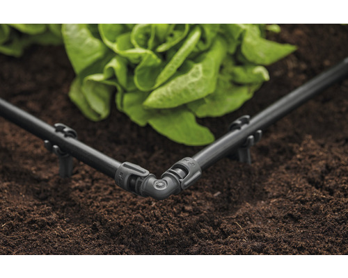 Hörnkoppling för bevattningssystem med droppslang i trädgårdsrabatt