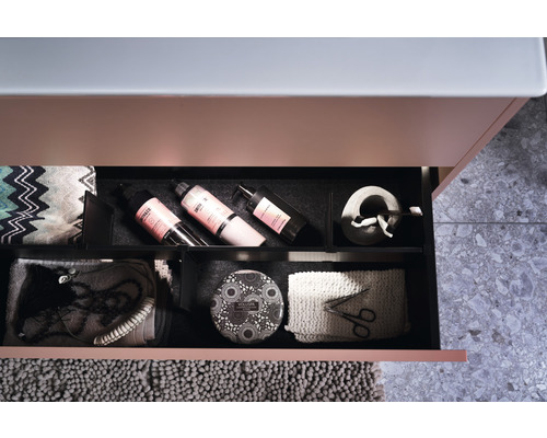 Öppen låda i ett badrumsskåp med badrumsartiklar.