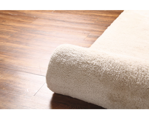 Detaljvy av en rullad matta på trägolv