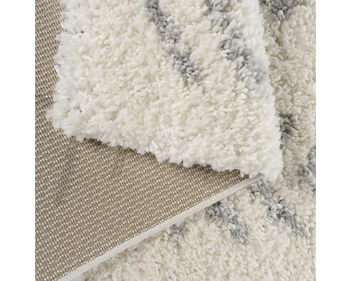 Detaljvy av en vit lurvig matta med mönster