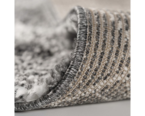 Detaljvy av en matta med melange-utseende och langetterade kanter