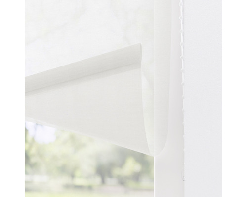 Detaljbild av en vit rullgardin framför ett fönster