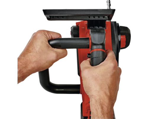 En person håller en motorsåg med två händer.