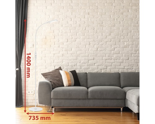 Golvlampa med en höjd på 1400 millimeter och en bredd på 735 millimeter bredvid en grå soffa