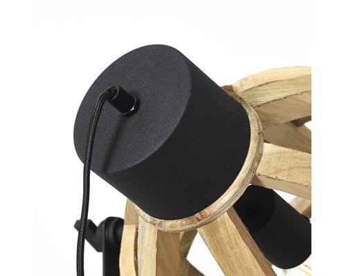 Detaljbild av en taklampa med svart sockel och träelement