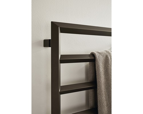 Handdukstork i metall på en vägg med en handduk