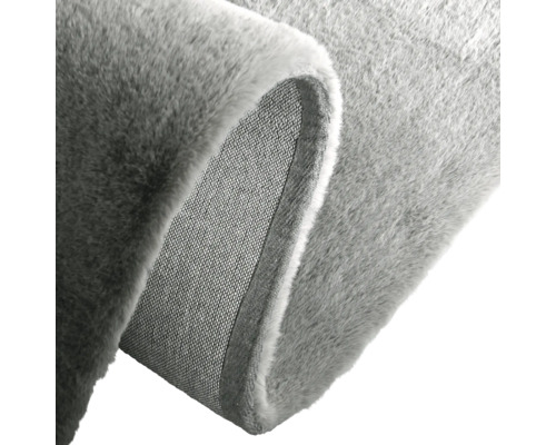 Detalj av en grå matta med vävd baksida