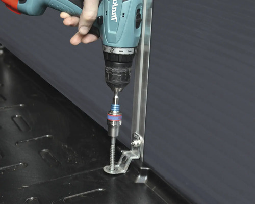 En person fäster en skruv på ett metallfäste med en sladdlös skruvdragare.
