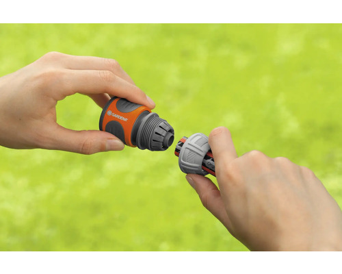 Två händer ansluter en Gardena slangkoppling.